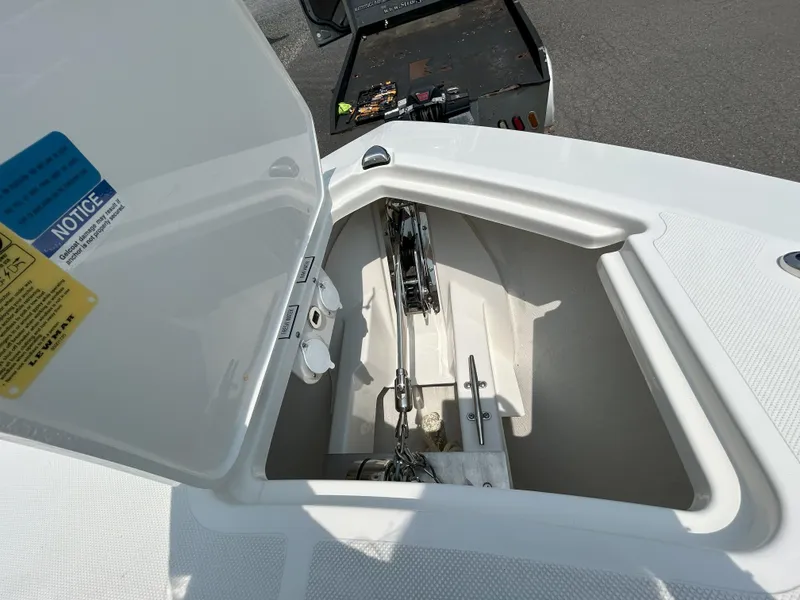 Slide: The Image of Open anchor compartment of 2026 Pursuit DC 326 boat, showcasing chain and storage area. - 18