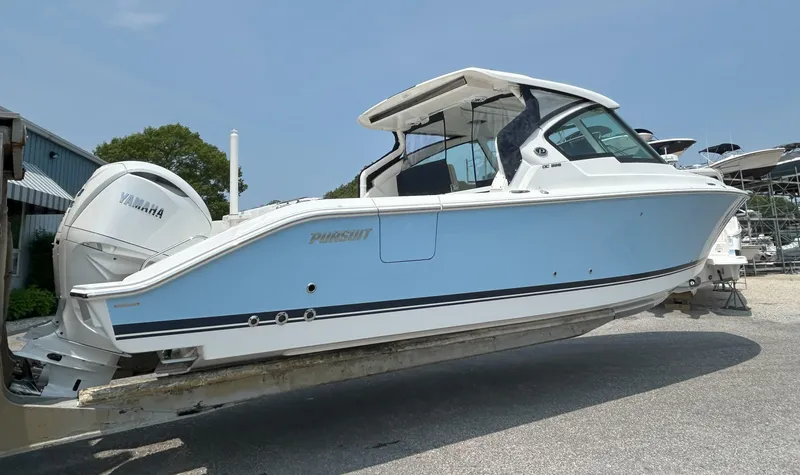 Slide: The Image of 2026 Pursuit DC 326 boat with Yamaha engines, light blue hull, on a trailer. - 3