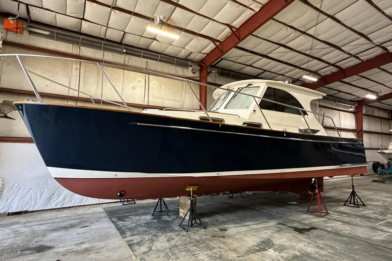 The Image of 2003 Legacy Yachts 34 Express in a warehouse, elevated on stands. - 0