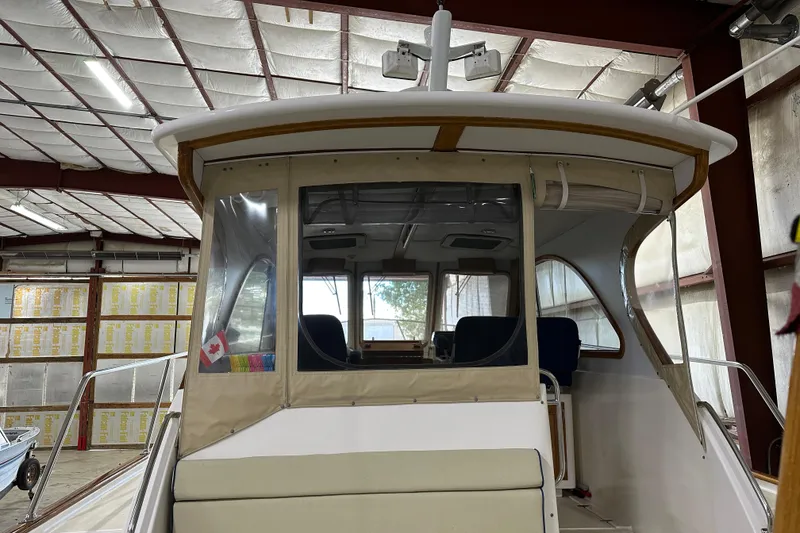 Slide: The Image of 2003 Legacy Yachts 34 Express in a warehouse, showcasing the cabin and helm area. - 10