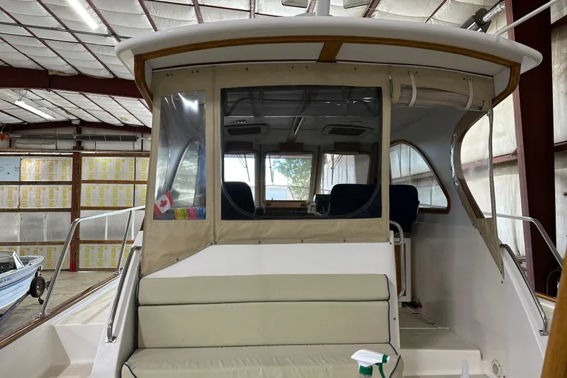 Slide: The Image of 2003 Legacy Yachts 34 Express in a warehouse, rear view with covered cockpit. - 11