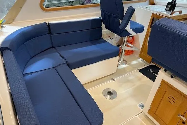 Slide: The Image of Interior of 2003 Legacy Yachts 34 Express with blue seating and wooden accents. - 13