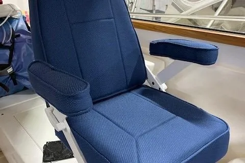 Slide: The Image of Blue captain's chair on 2003 Legacy Yachts 34 Express boat, featuring armrests and cushioned seating. - 14