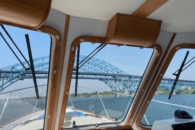 Slide: The Image of 2003 Legacy Yachts 34 Express cruising under a blue steel bridge. - 17
