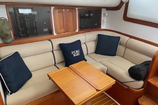 Slide: The Image of 2003 Legacy Yachts 34 Express interior with beige seating and wooden table. - 19