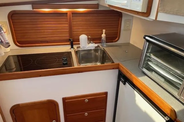 Slide: The Image of Compact kitchen in 2003 Legacy Yachts 34 Express with stove, sink, and toaster oven. - 21