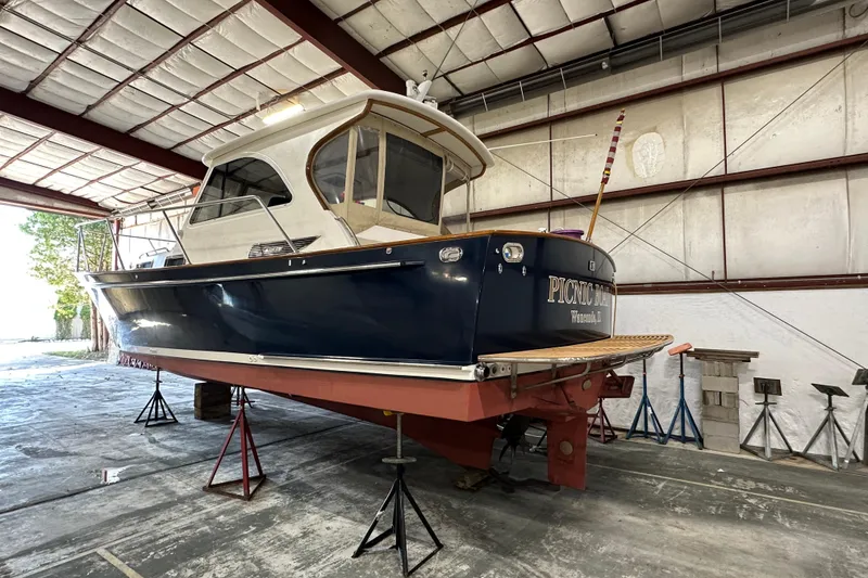 Slide: The Image of 2003 Legacy Yachts 34 Express in storage, elevated on stands, inside a spacious warehouse. - 3