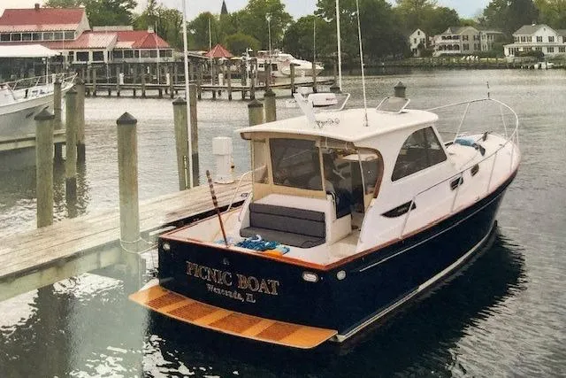 Slide: The Image of 2003 Legacy Yachts 34 Express docked at a marina with scenic waterfront views. - 35