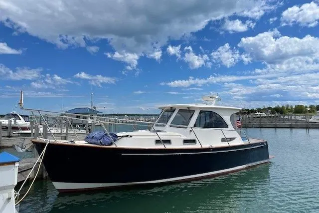 Slide: The Image of 2003 Legacy Yachts 34 Express docked under a blue sky with clouds. - 42