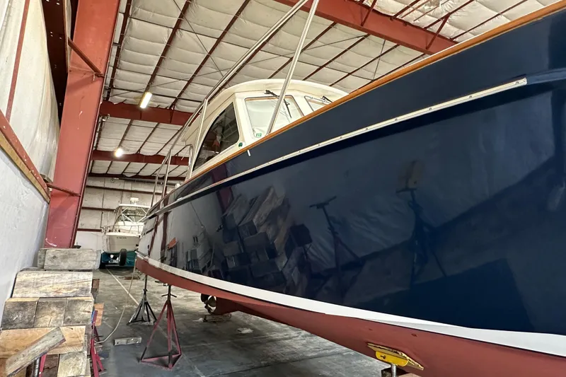 Slide: The Image of 2003 Legacy Yachts 34 Express in storage, showcasing sleek blue hull design. - 7