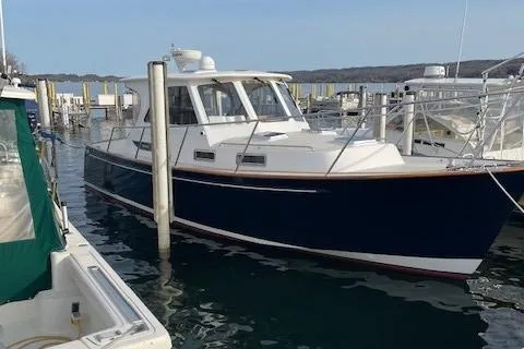 Slide: The Image of 2003 Legacy Yachts 34 Express docked in a marina, featuring a sleek blue hull. - 8