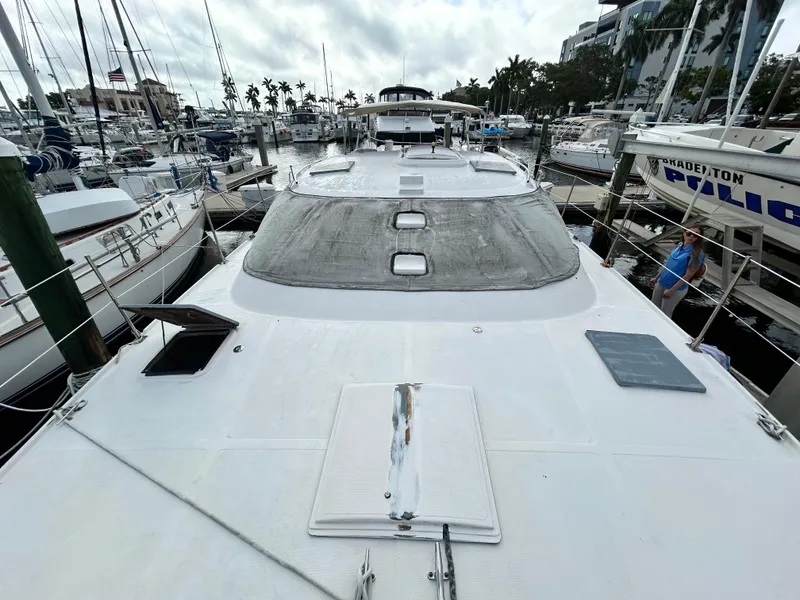Slide: The Image of 2004 Endeavour Catamaran Victory docked at a marina, view of the deck and surrounding boats. - 13