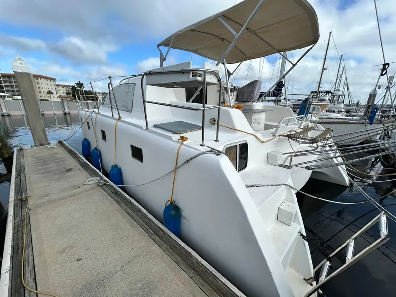 Slide: The Image of 2004 Endeavour Catamaran Victory docked at marina with blue fenders and canopy. - 3