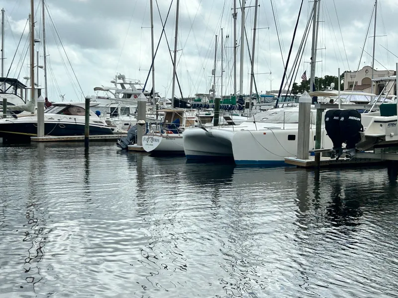 Slide: The Image of Boats docked at a marina, featuring a 2004 Endeavour Catamaran Victory. - 7