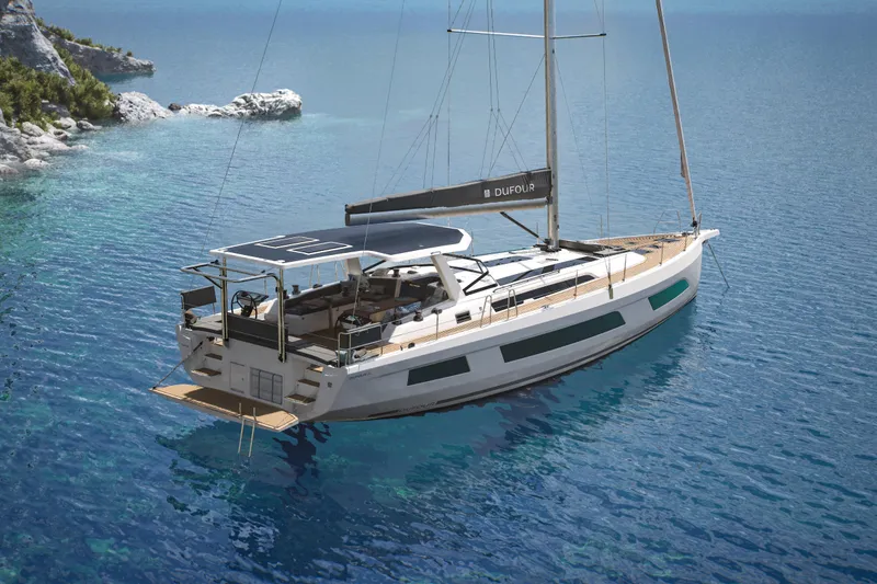 The Image of 2026 Dufour 54 yacht sailing in clear blue waters near rocky coastline. - 0