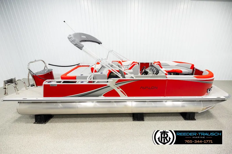 The Image of 2026 Avalon LSZ VRB pontoon boat, red and silver design, displayed indoors at Reeder-Trausch Marine. - 1
