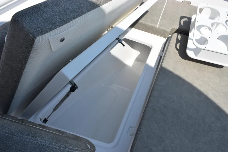 Slide: The Image of Open storage compartment on 2026 Sea Hunt Ultra 265 SE boat, featuring cushioned seating. - 16