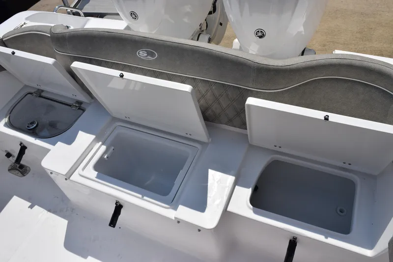 Slide: The Image of 2026 Sea Hunt Ultra 265 SE boat with open storage compartments and cushioned seating. - 23