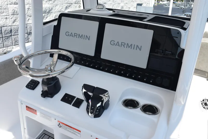 Slide: The Image of 2026 Sea Hunt Ultra 265 SE boat dashboard with Garmin navigation displays and steering wheel. - 9