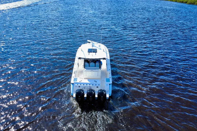 Slide: The Image of 2022 Robalo R360 Center Console boat cruising on open water, rear view. - 15