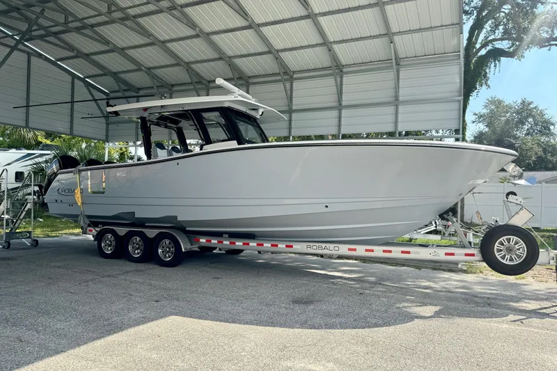 Slide: The Image of 2022 Robalo R360 Center Console boat on trailer under metal canopy. - 17