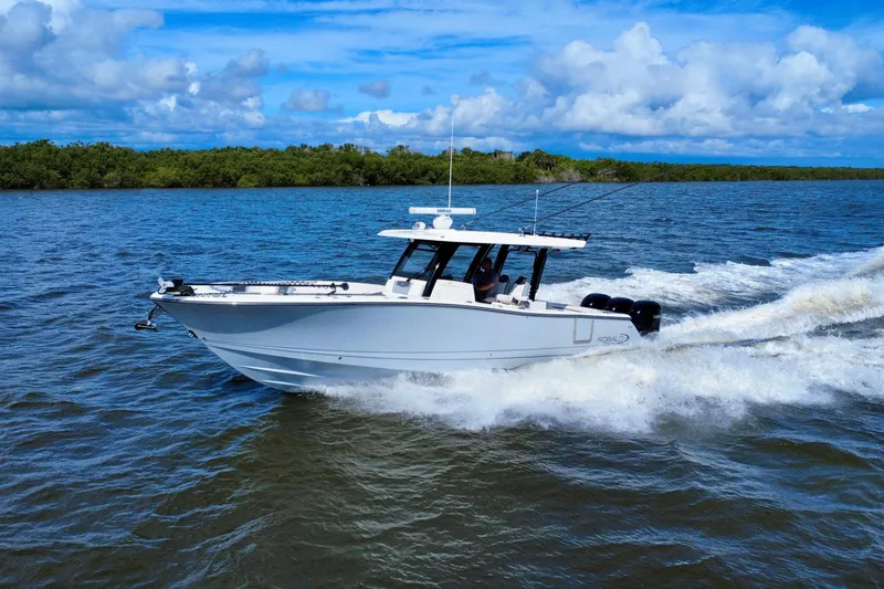 Slide: The Image of 2022 Robalo R360 Center Console boat cruising on open water under blue skies. - 2