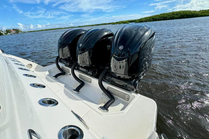 Slide: The Image of 2022 Robalo R360 Center Console with triple outboard engines on water. - 21