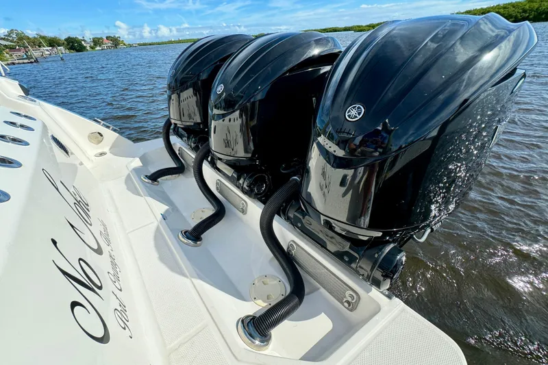 Slide: The Image of 2022 Robalo R360 Center Console with triple outboard engines on water. - 23