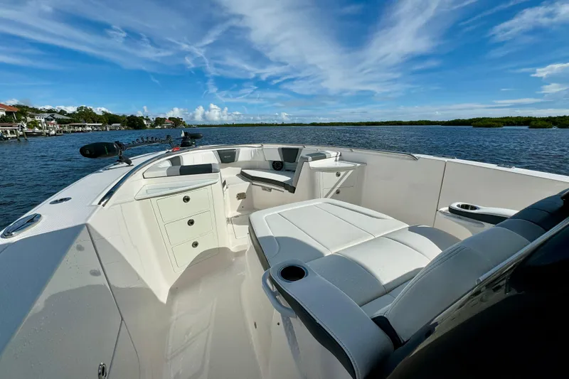 Slide: The Image of 2022 Robalo R360 Center Console boat interior with seating and storage, on a sunny day. - 27
