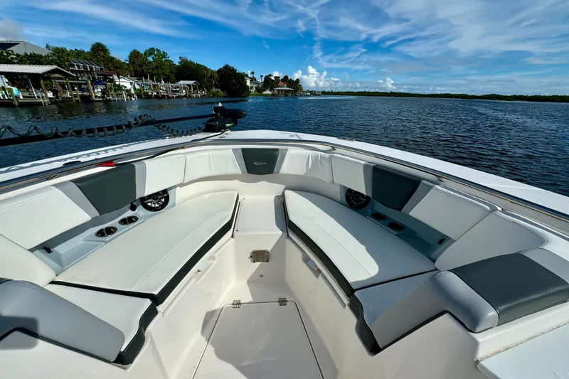 Slide: The Image of 2022 Robalo R360 Center Console boat interior with spacious seating on a calm lake. - 28