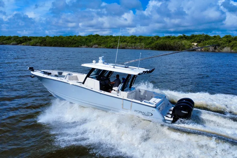 Slide: The Image of 2022 Robalo R360 Center Console boat cruising on open water, under a blue sky. - 3