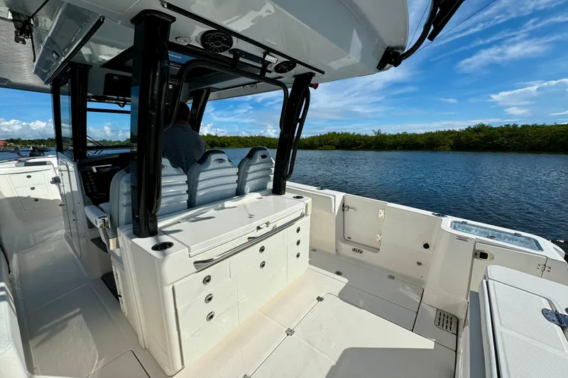 Slide: The Image of 2022 Robalo R360 Center Console boat interior with seating and storage, on a sunny day. - 37