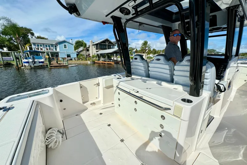 Slide: The Image of 2022 Robalo R360 Center Console boat interior with seating and waterfront view. - 38