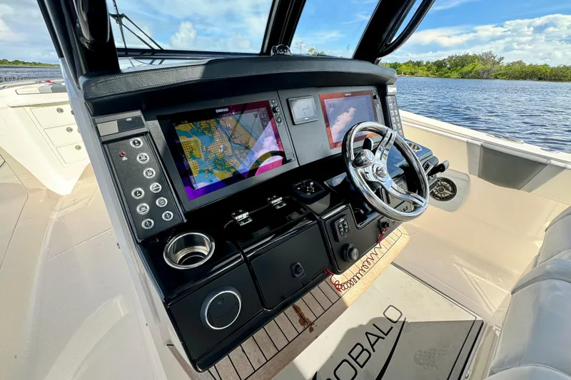 Slide: The Image of 2022 Robalo R360 Center Console boat dashboard with navigation screens and steering wheel. - 42