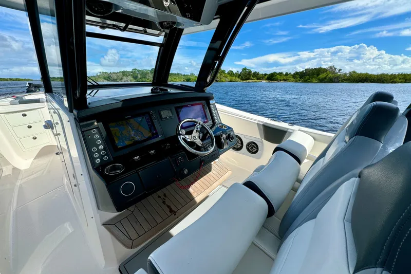 Slide: The Image of 2022 Robalo R360 Center Console boat interior with advanced navigation system on a sunny day. - 43