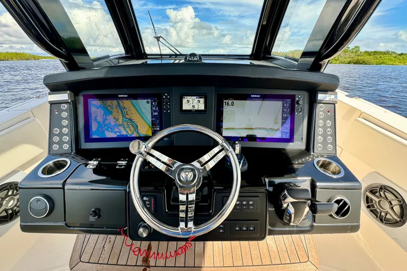 Slide: The Image of 2022 Robalo R360 Center Console helm with dual navigation screens and steering wheel. - 45