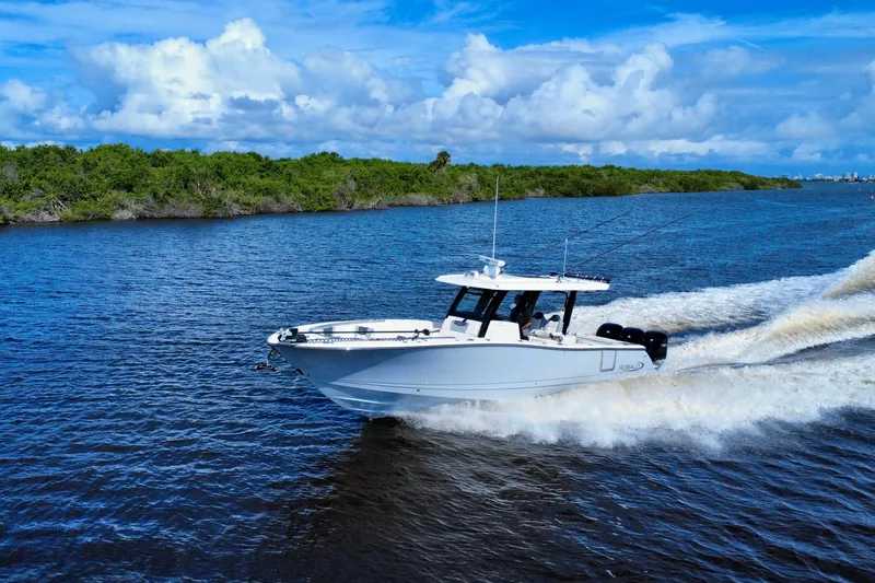 Slide: The Image of 2022 Robalo R360 Center Console boat cruising on a scenic waterway. - 5