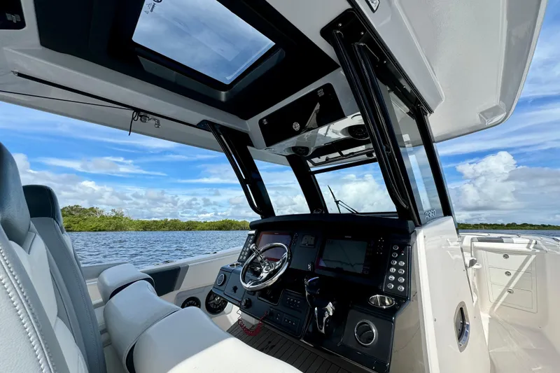 Slide: The Image of 2022 Robalo R360 Center Console boat interior with modern dashboard and scenic water view. - 51