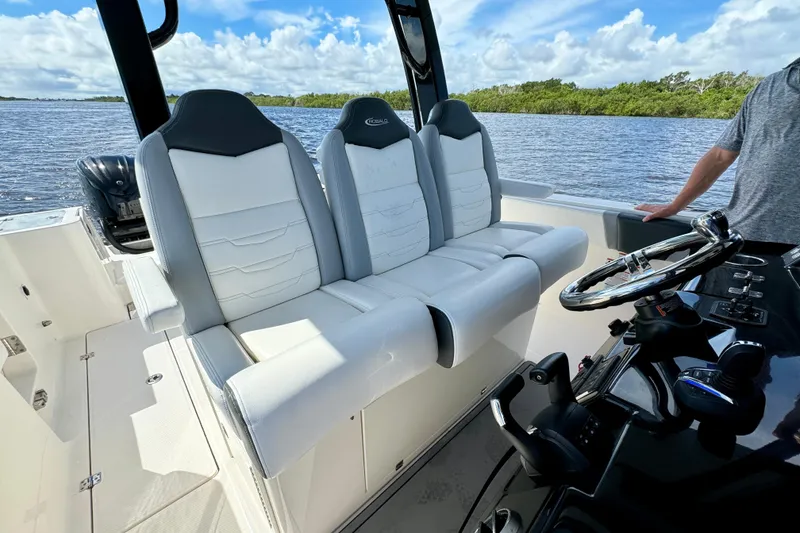 Slide: The Image of 2022 Robalo R360 Center Console boat interior with white seating and steering wheel. - 53