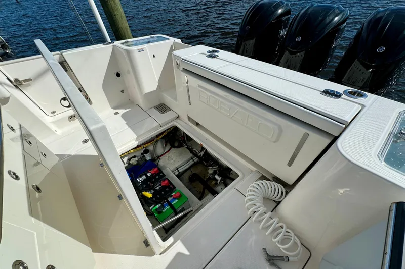 Slide: The Image of 2022 Robalo R360 Center Console boat with open storage compartment and visible engines. - 55