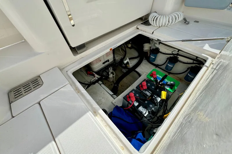 Slide: The Image of 2022 Robalo R360 Center Console boat battery compartment with wiring and equipment. - 56