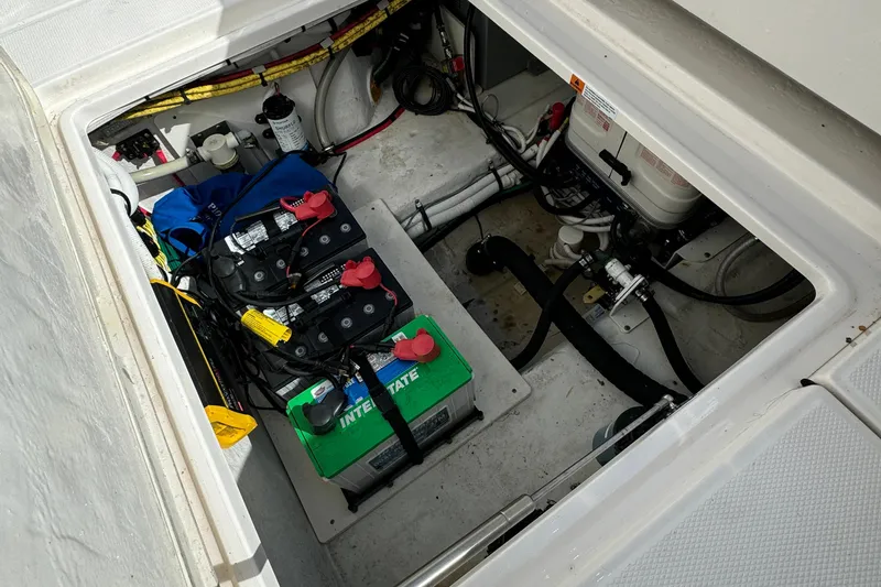 Slide: The Image of 2022 Robalo R360 Center Console boat battery compartment with wiring and equipment. - 57