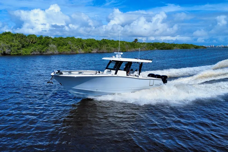 Slide: The Image of 2022 Robalo R360 Center Console boat cruising on a scenic waterway. - 6