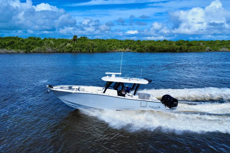 Slide: The Image of 2022 Robalo R360 Center Console boat cruising on a scenic waterway. - 7