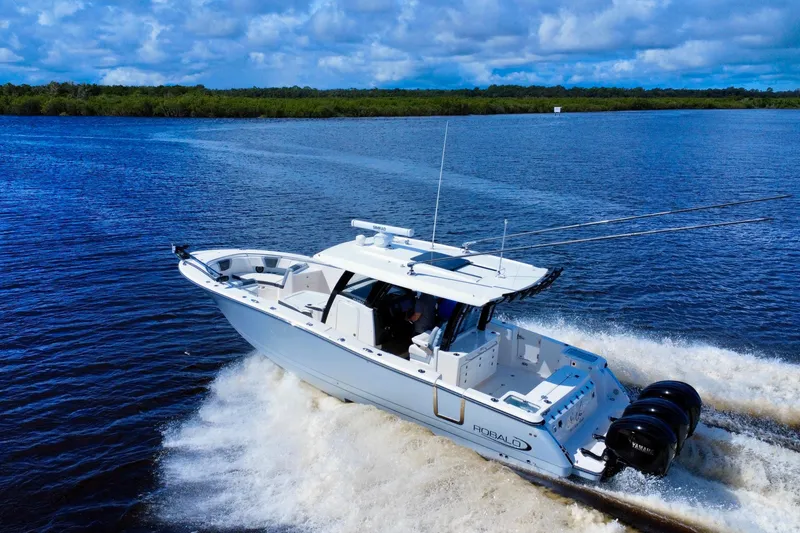 Slide: The Image of 2022 Robalo R360 Center Console boat cruising on a scenic waterway. - 9
