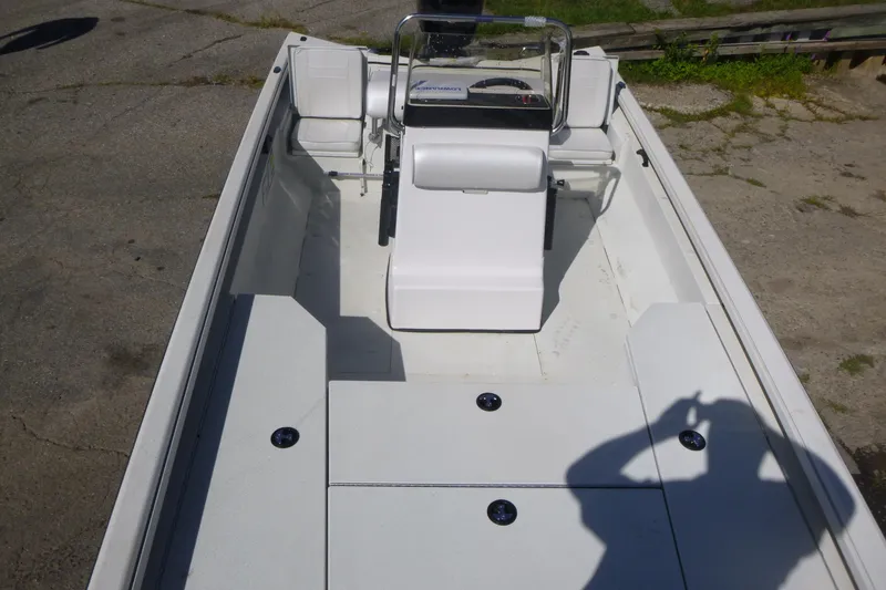 Slide: The Image of 2024 Ranger RB200 boat interior with seating and console, parked on pavement. - 6