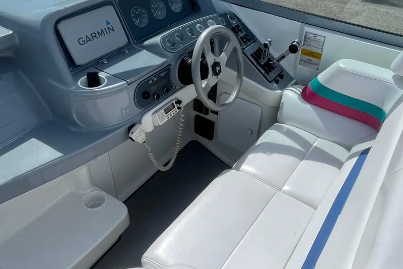 Slide: The Image of 1996 Formula 330 Sun Sport boat cockpit with Garmin navigation and white seating. - 14