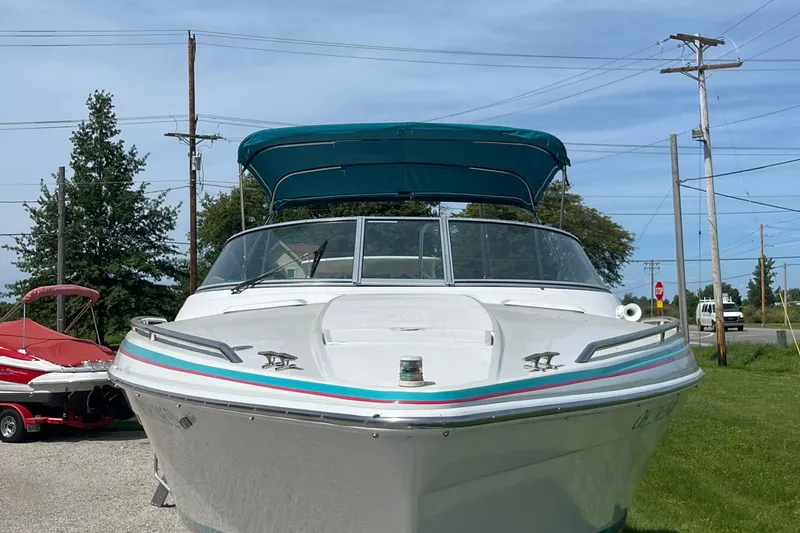 Slide: The Image of 1996 Formula 330 Sun Sport boat with teal canopy, parked outdoors. - 3