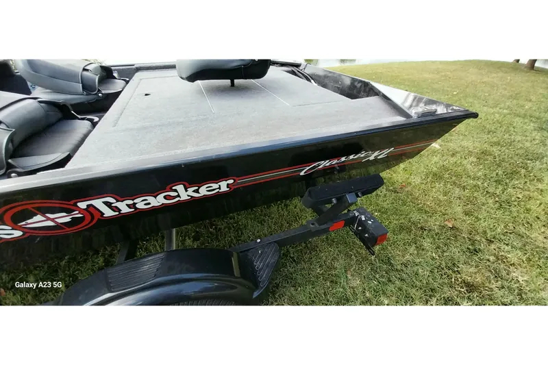 Slide: The Image of 2023 Tracker Bass Tracker Classic XL boat on grass, featuring trailer attachment. - 21