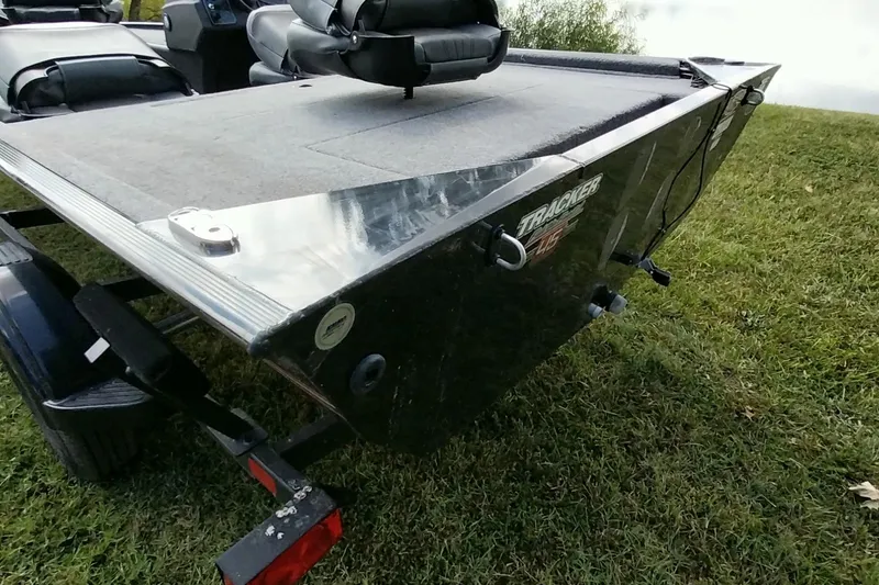 Slide: The Image of 2023 Tracker Bass Tracker Classic XL boat on grassy terrain, rear view. - 23